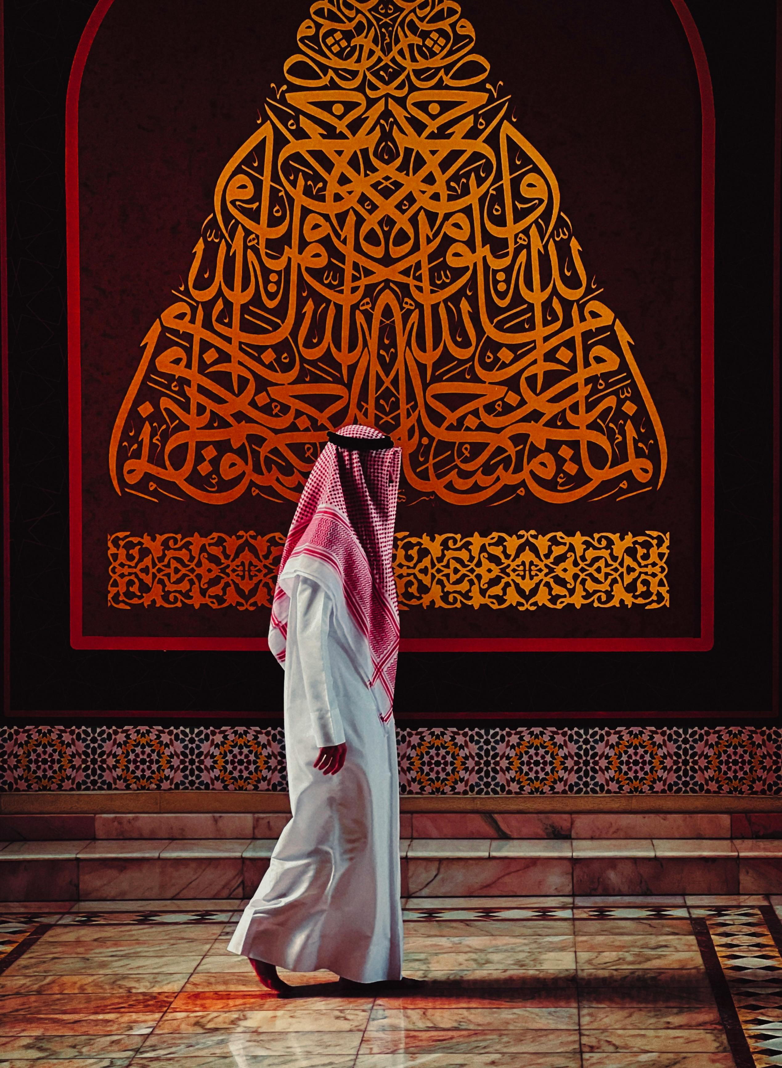 Middle Eastern Man in Traditional Attire with Arabic Calligraphy